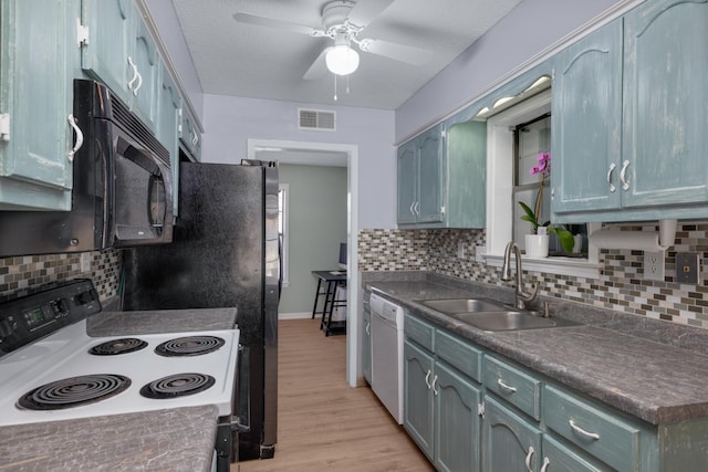 kitchen featuring visible vents, electric stove, a sink, black microwave, and dishwasher