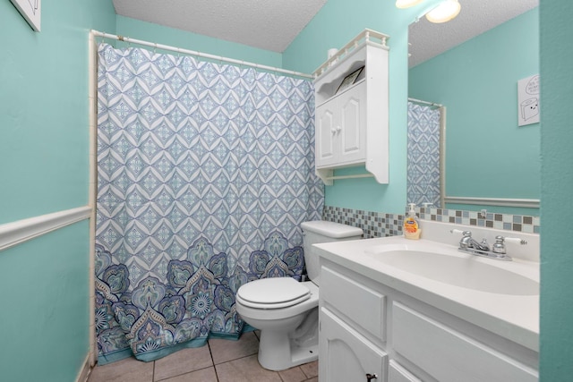 full bathroom with tile patterned floors, a wainscoted wall, toilet, a textured ceiling, and vanity