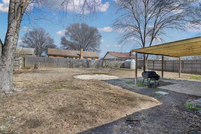 view of yard with a storage unit, an outbuilding, and a fenced backyard