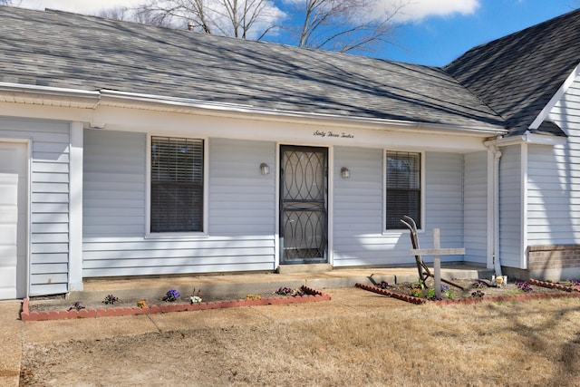 property entrance featuring a porch, a shingled roof, and a garage