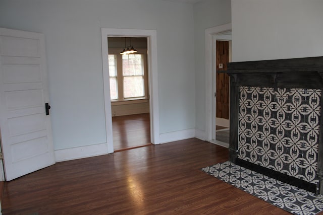 unfurnished living room featuring baseboards and wood finished floors