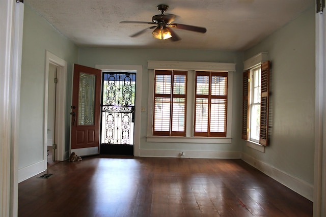 foyer featuring ceiling fan, visible vents, baseboards, and wood finished floors