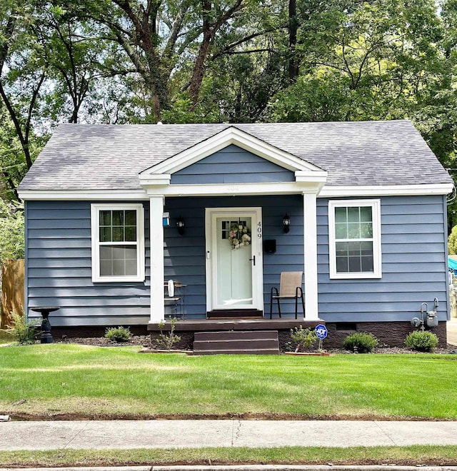 view of front of property featuring a front yard and roof with shingles