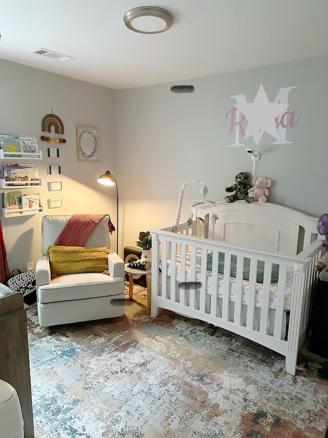 bedroom featuring visible vents and a crib