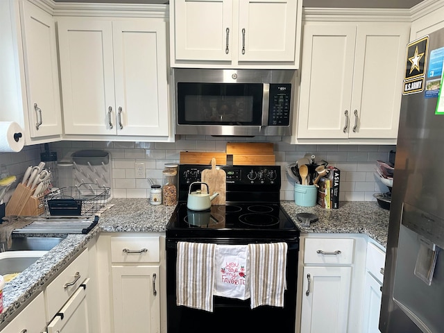 kitchen with stainless steel appliances, light stone countertops, tasteful backsplash, and white cabinets