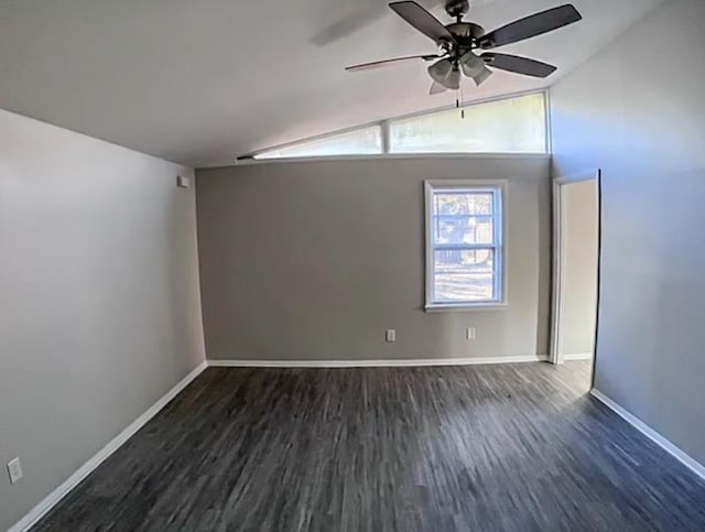 empty room featuring dark wood finished floors, vaulted ceiling, baseboards, and ceiling fan