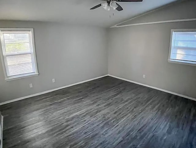 empty room featuring baseboards, lofted ceiling, ceiling fan, and dark wood-style flooring