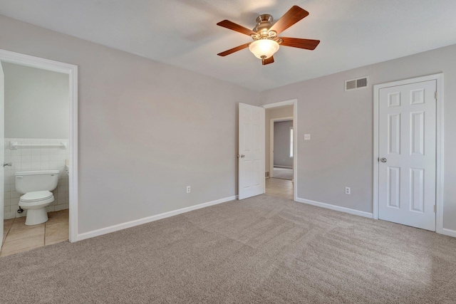 unfurnished bedroom with visible vents, ensuite bathroom, carpet flooring, baseboards, and ceiling fan