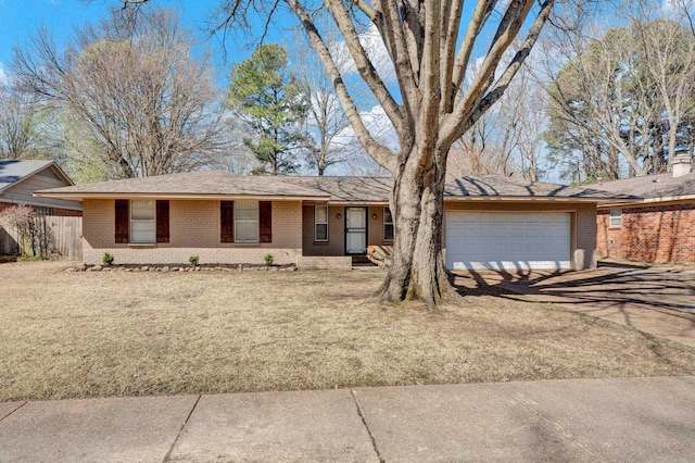 ranch-style house with fence, a front lawn, concrete driveway, a garage, and brick siding