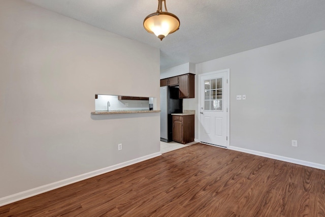 unfurnished living room featuring baseboards and light wood-style floors