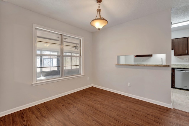 unfurnished dining area featuring light wood finished floors and baseboards