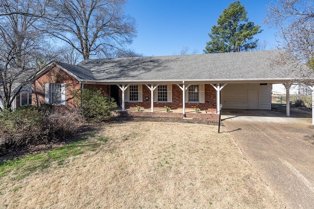 ranch-style house with brick siding, an attached carport, dirt driveway, a porch, and roof with shingles