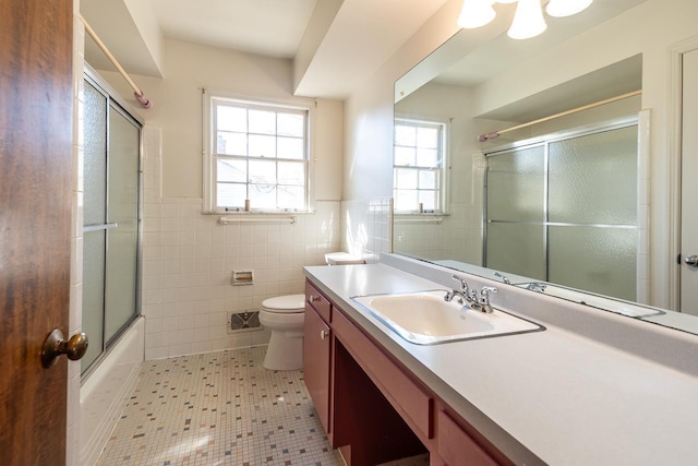 bathroom featuring vanity, tile walls, wainscoting, and toilet