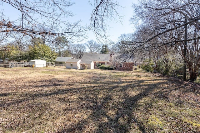 view of yard featuring an outbuilding and fence