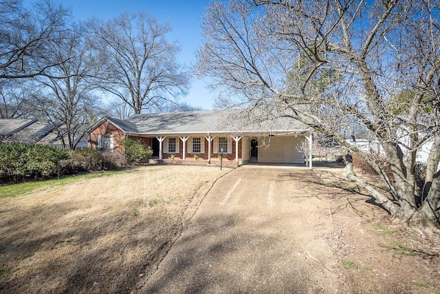 view of front facade featuring brick siding, driveway, and a front lawn