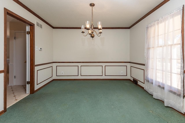 carpeted empty room featuring a wainscoted wall, crown molding, a notable chandelier, and visible vents