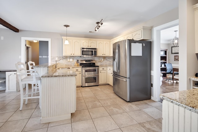 kitchen featuring decorative backsplash, a peninsula, light tile patterned flooring, and stainless steel appliances