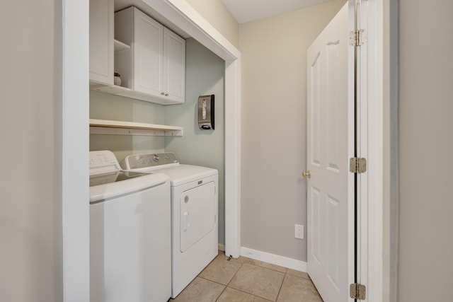 laundry room with cabinet space, light tile patterned floors, independent washer and dryer, and baseboards