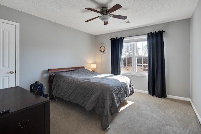 bedroom with visible vents, baseboards, light colored carpet, and a textured ceiling