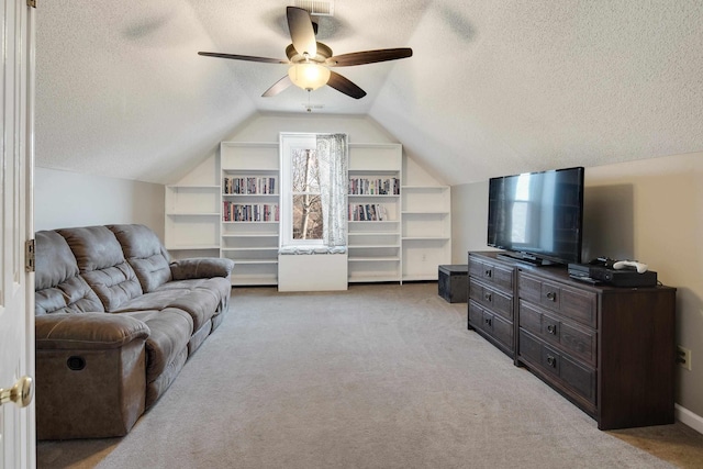 living room featuring built in features, a textured ceiling, light colored carpet, ceiling fan, and vaulted ceiling