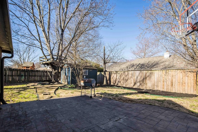 view of patio / terrace featuring an outbuilding, a grill, a fenced backyard, and a shed