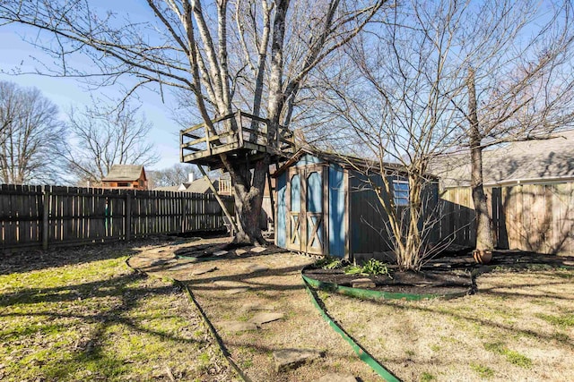 view of yard with a fenced backyard, a shed, and an outdoor structure