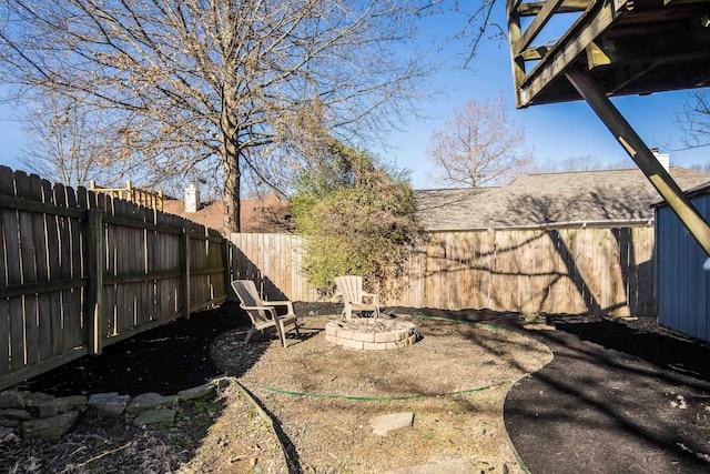 view of yard featuring a fire pit and a fenced backyard