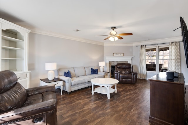 living room featuring visible vents, dark wood finished floors, a fireplace, ceiling fan, and crown molding