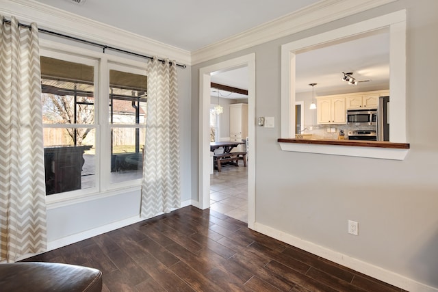 interior space featuring baseboards, crown molding, and dark wood-type flooring