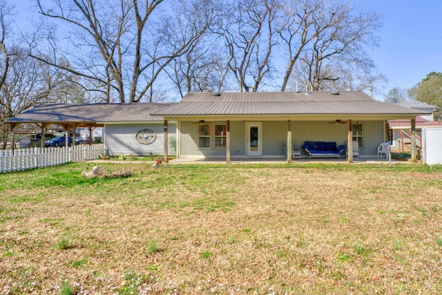 rear view of property featuring an attached carport, a ceiling fan, fence, and a patio