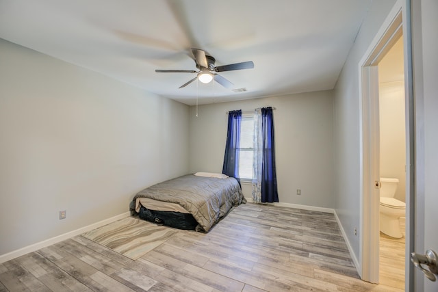 bedroom featuring visible vents, a ceiling fan, baseboards, and wood finished floors