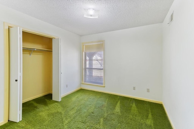 unfurnished bedroom featuring visible vents, baseboards, carpet, a closet, and a textured ceiling