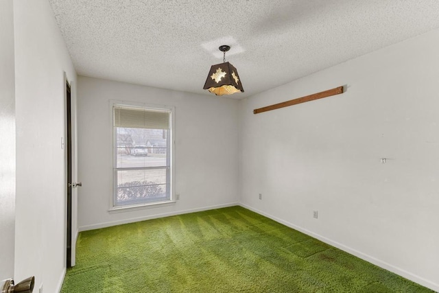 spare room featuring carpet flooring, a textured ceiling, and baseboards