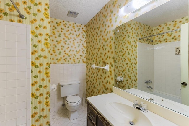 full bathroom with visible vents, a textured ceiling, wallpapered walls, and walk in shower