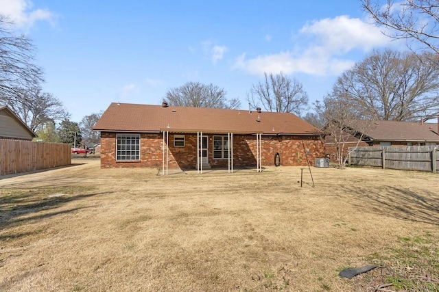 rear view of house featuring fence and brick siding