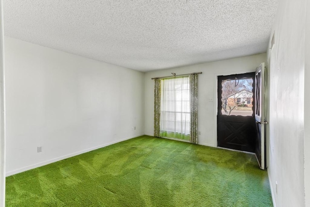 carpeted empty room with baseboards and a textured ceiling