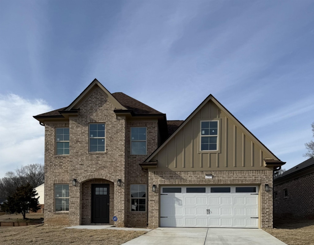 view of front facade featuring a garage, brick siding, board and batten siding, and concrete driveway