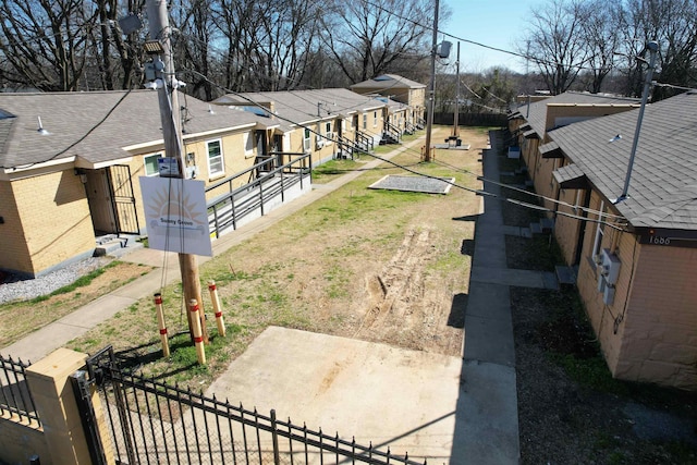 view of yard featuring a gate, a residential view, and a fenced front yard