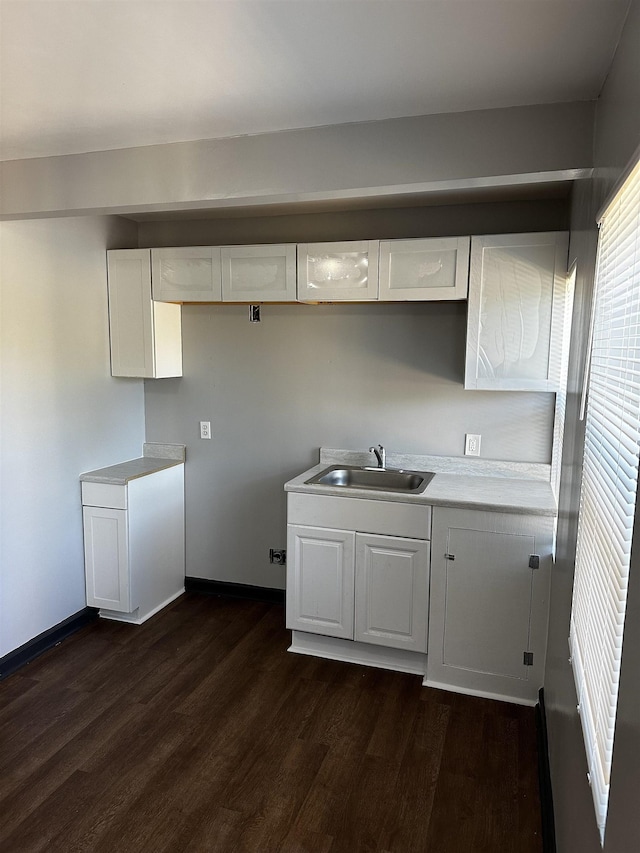 kitchen featuring white cabinetry, light countertops, dark wood-style floors, and a sink