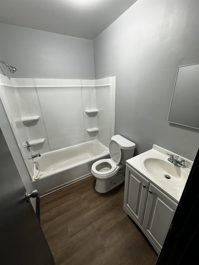 full bath with vanity, toilet, wood finished floors, and shower / bathtub combination