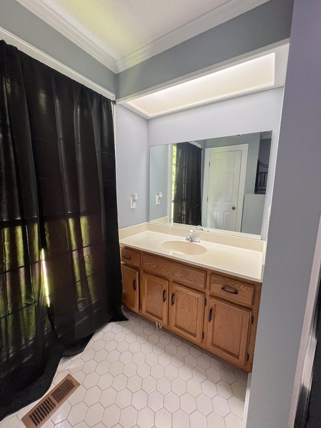 bathroom with vanity, crown molding, visible vents, and a textured ceiling