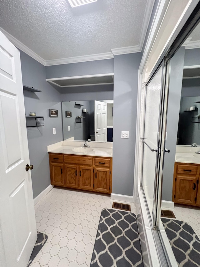 bathroom with vanity, baseboards, a stall shower, ornamental molding, and a textured ceiling