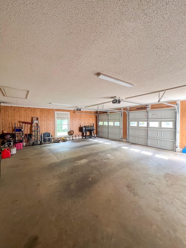 garage featuring wood walls and a garage door opener