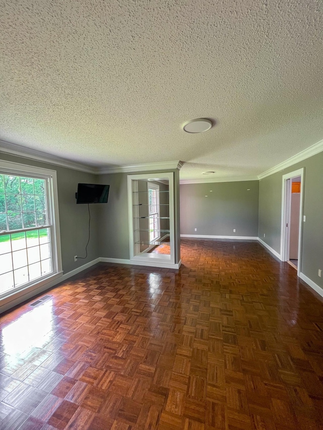 unfurnished room with a textured ceiling, baseboards, visible vents, and ornamental molding