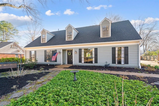 cape cod-style house featuring roof with shingles