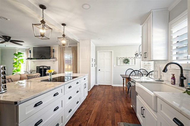 kitchen with black electric stovetop, light stone countertops, tasteful backsplash, and dark wood-style flooring