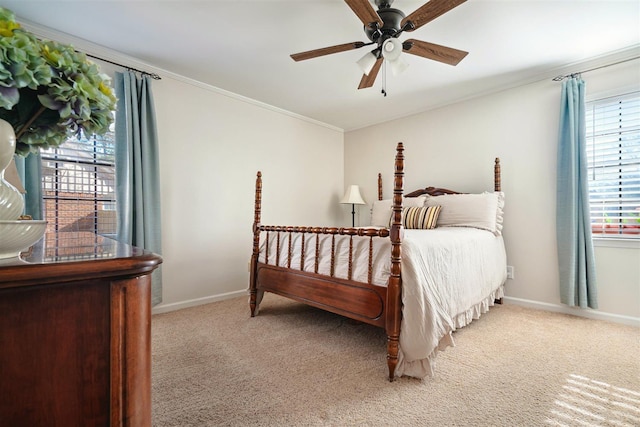 carpeted bedroom featuring baseboards, ceiling fan, and crown molding