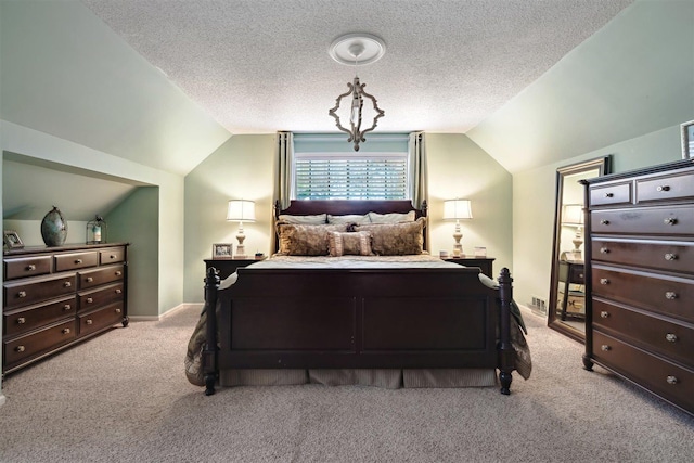 carpeted bedroom featuring visible vents, a textured ceiling, and vaulted ceiling