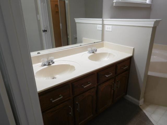 bathroom with a sink, a bathing tub, double vanity, and tile patterned floors