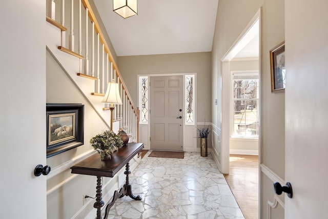 entryway with vaulted ceiling, stairway, baseboards, and marble finish floor